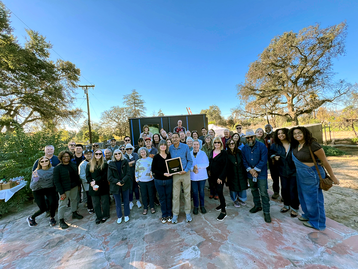 Large group of people standing in front of factory-built house in Altadena.